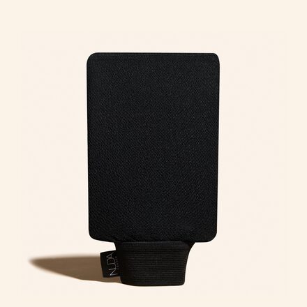 Gant exfoliant NUDA pour pr&eacute;parer la peau avant un autobronzant.